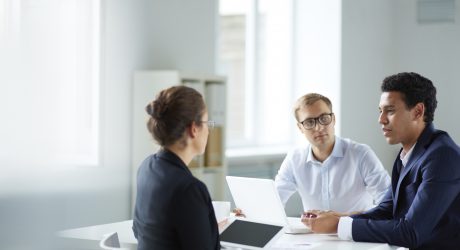 Portrait of smart business partners communicating at meeting